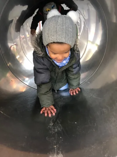 Kind kriecht durch Röhre